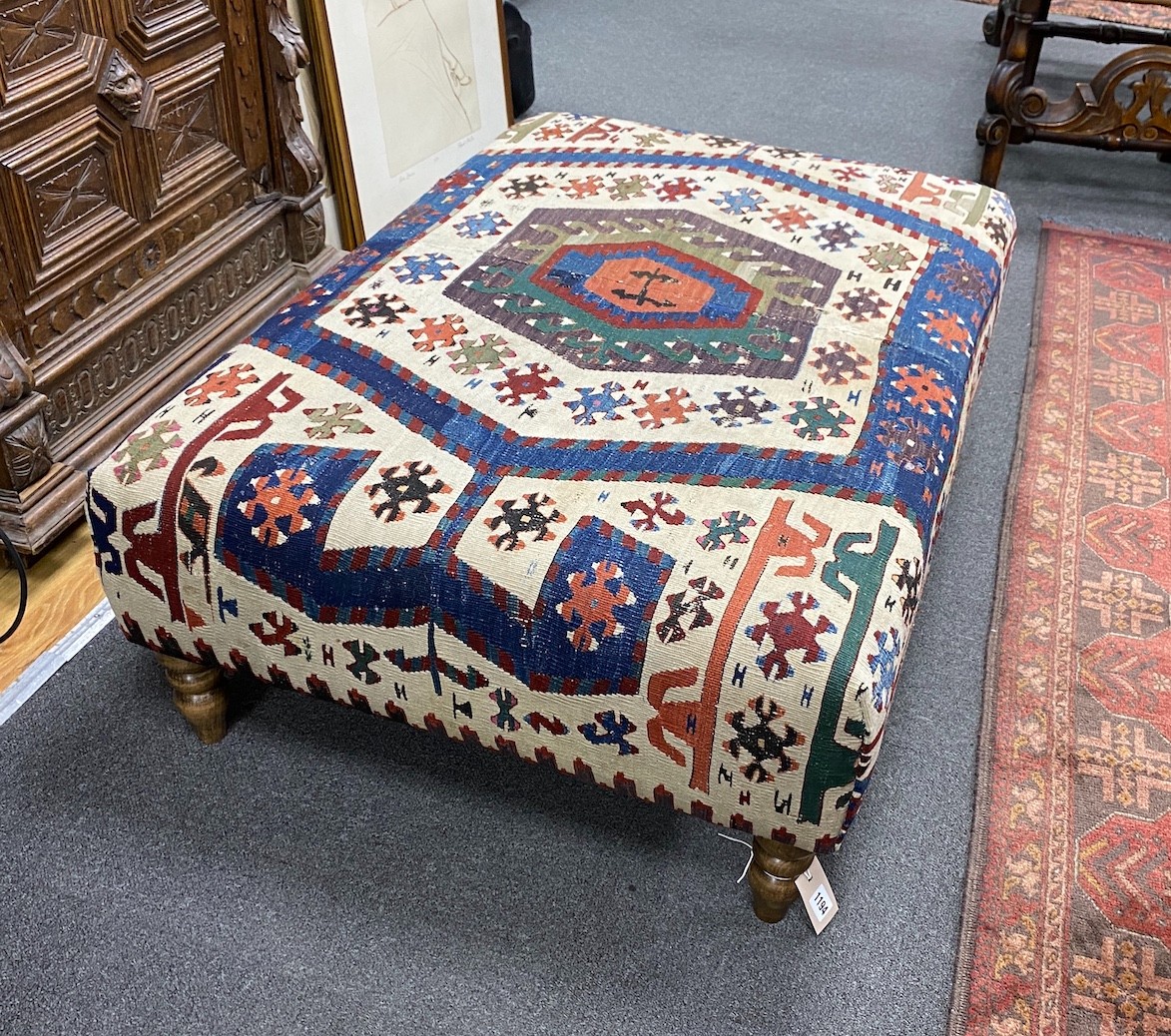 A large rectangular coffee table / footstool with antique kelim upholstery on stained turned beech feet, width 107cms, depth 72cms, height 37cms.